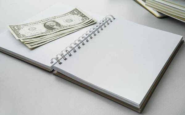 Billetes y una libreta sobre una mesa